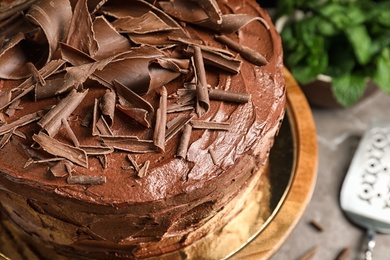 Photo of Stand with tasty chocolate cake on table, closeup