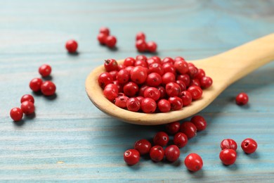 Photo of Aromatic spice. Red pepper in scoop on light blue wooden table, closeup