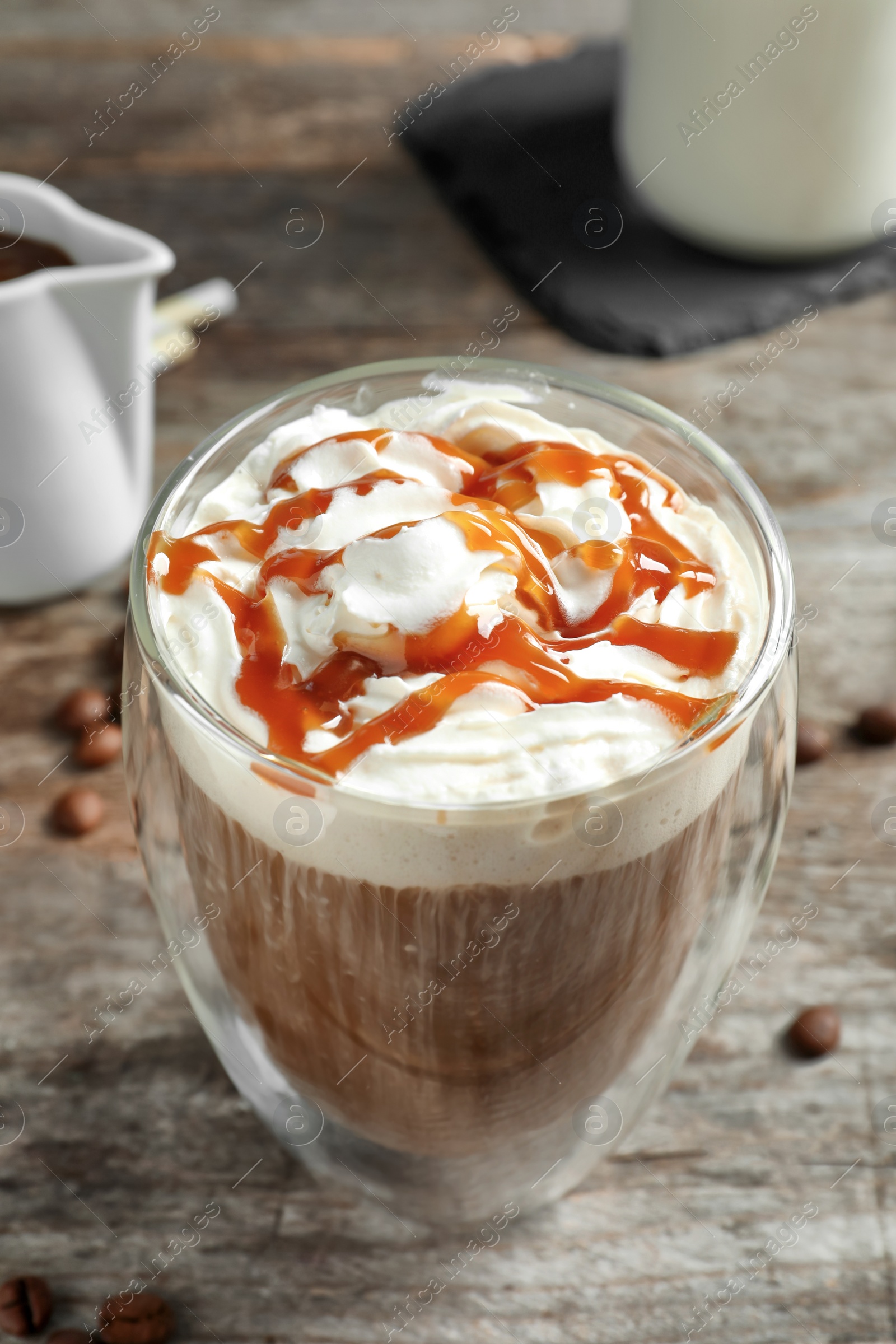 Photo of Glass of coffee with caramel topping on wooden background