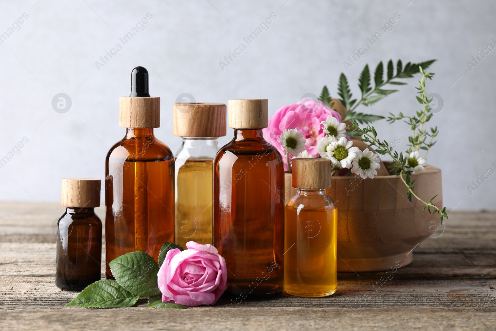 Photo of Aromatherapy. Different essential oils and flowers on wooden table