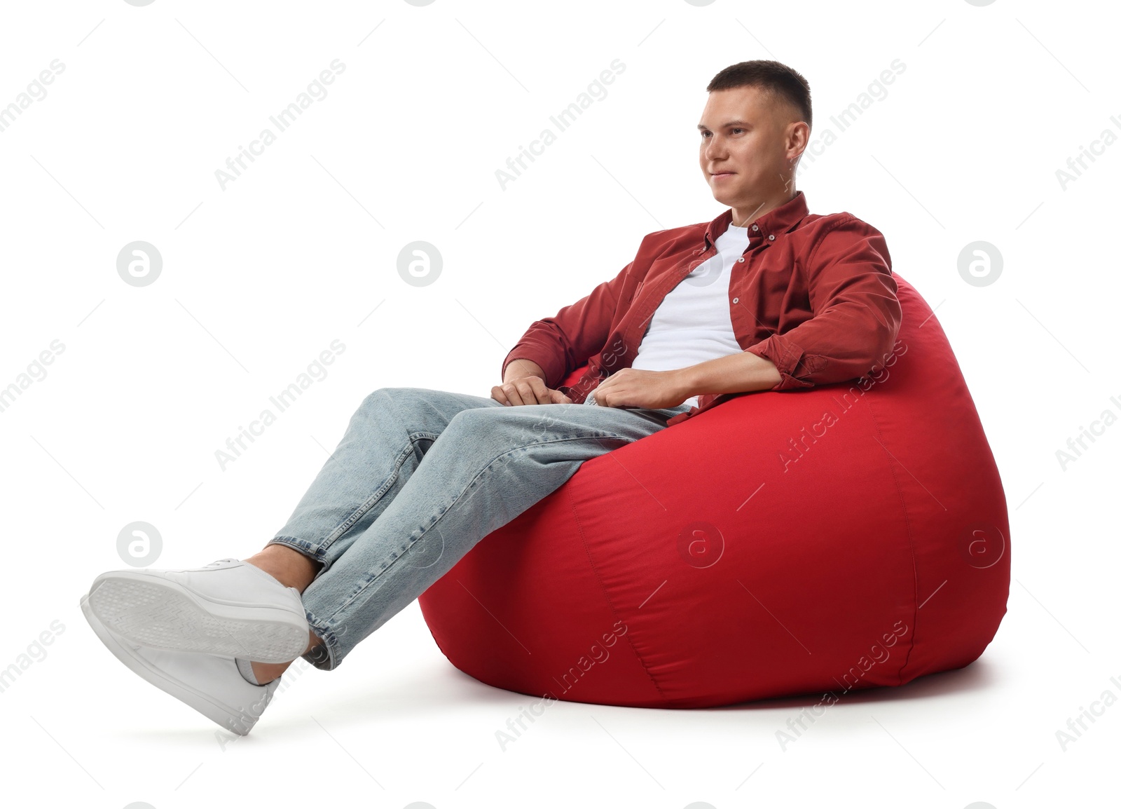 Photo of Handsome man sitting on red bean bag chair against white background