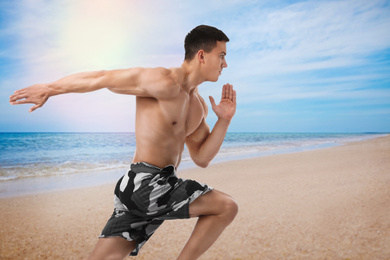 Image of Athletic young man running near sea on sunny day
