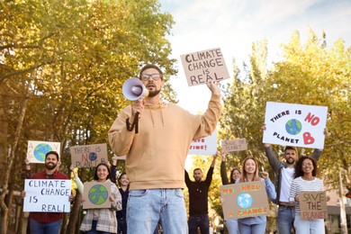 Photo of Group of people with posters protesting against climate change outdoors