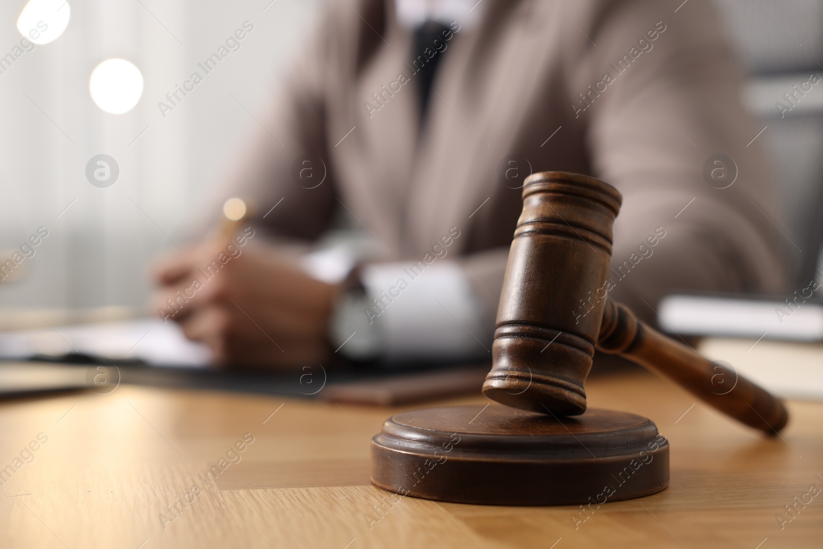 Photo of Lawyer working at table in office, focus on gavel