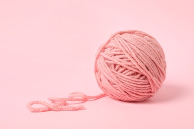 Photo of Soft colorful woolen yarn on light pink background. Space for text
