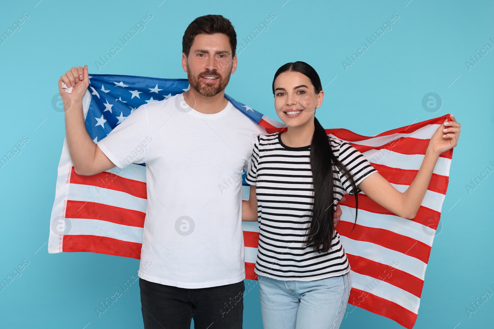 Photo of 4th of July - Independence Day of USA. Happy couple with American flag on light blue background