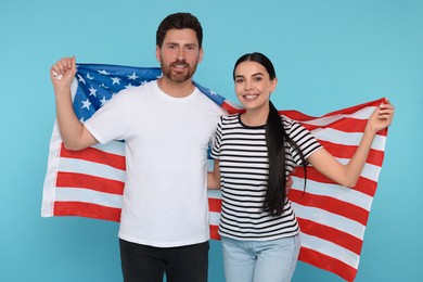 4th of July - Independence Day of USA. Happy couple with American flag on light blue background