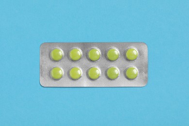 Photo of Pills in blister on blue background, top view
