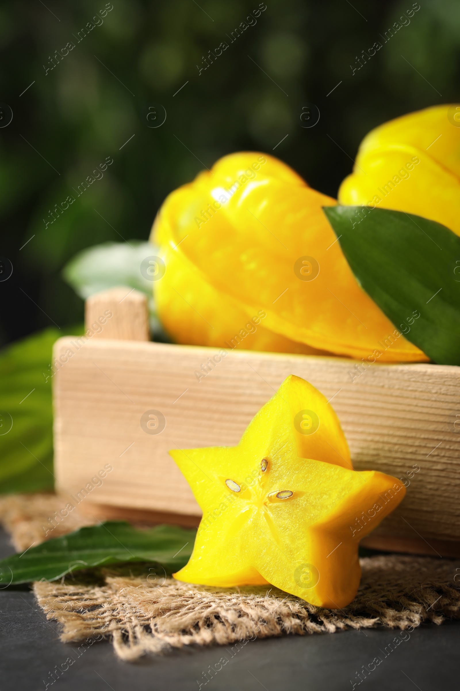 Photo of Delicious carambola fruits and slice on black table