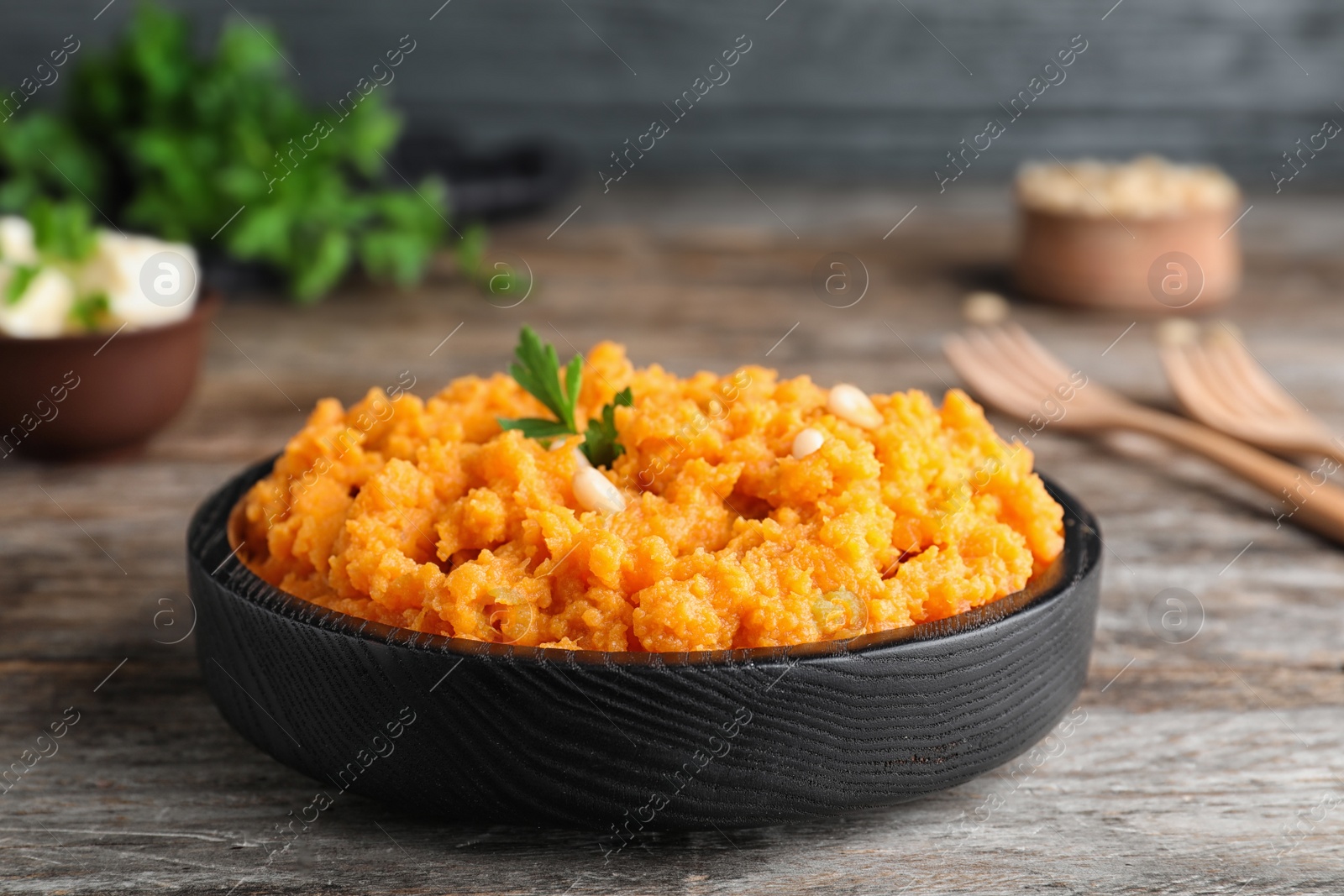 Photo of Plate with mashed sweet potatoes on wooden table