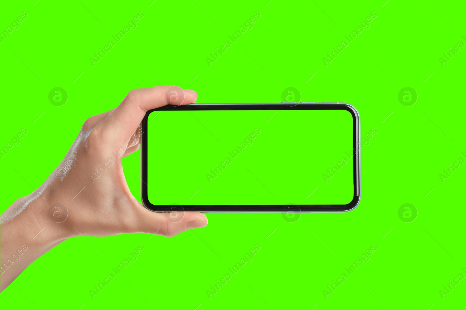 Image of Young woman holding smartphone with green screen on color background, closeup. Mockup for design