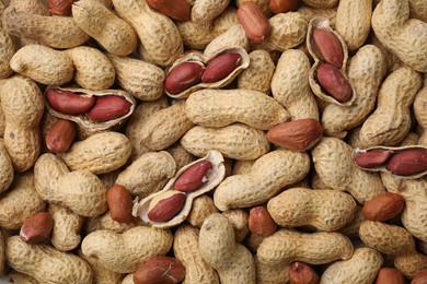 Many fresh unpeeled peanuts as background, top view