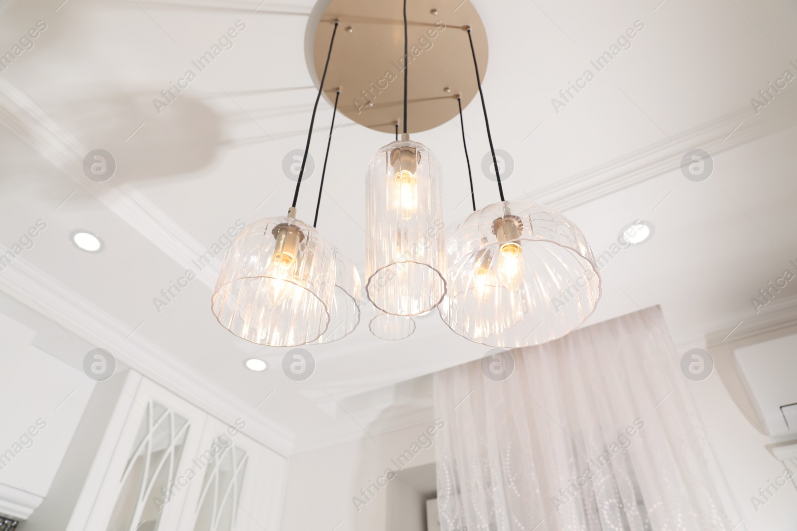 Photo of Stylish pendant lamp with light bulbs on ceiling in  modern room