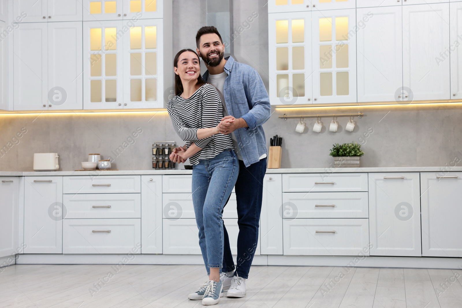 Photo of Happy lovely couple dancing together in kitchen