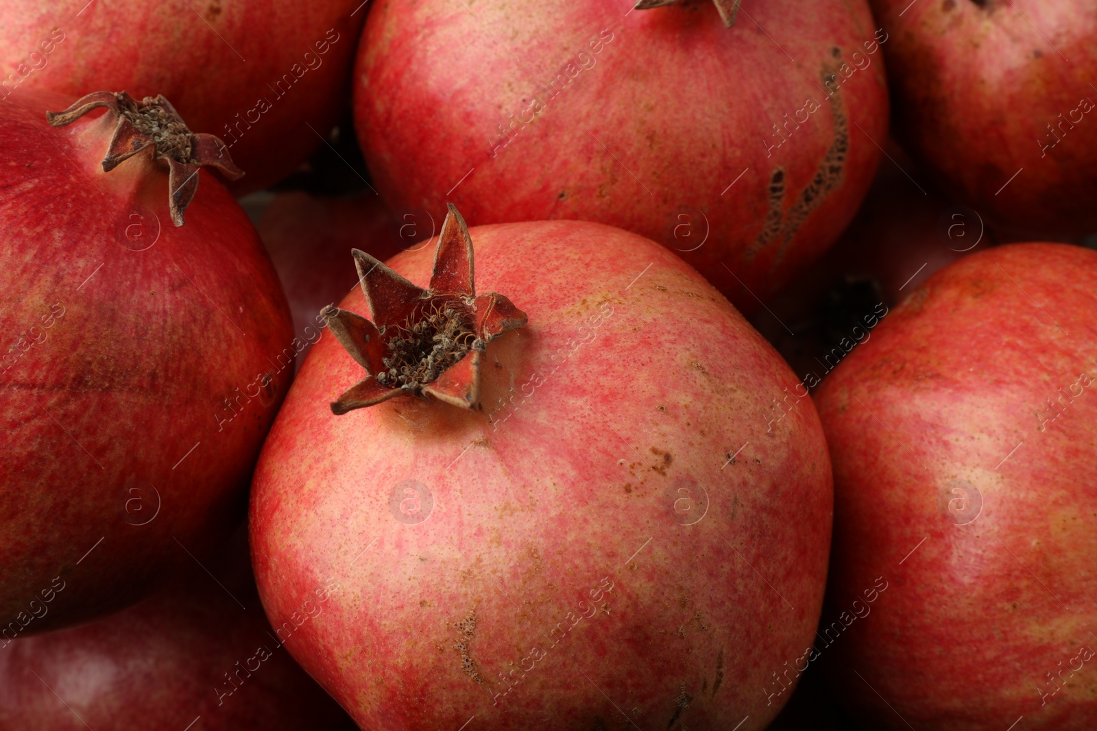 Photo of Many fresh ripe pomegranates as background, closeup