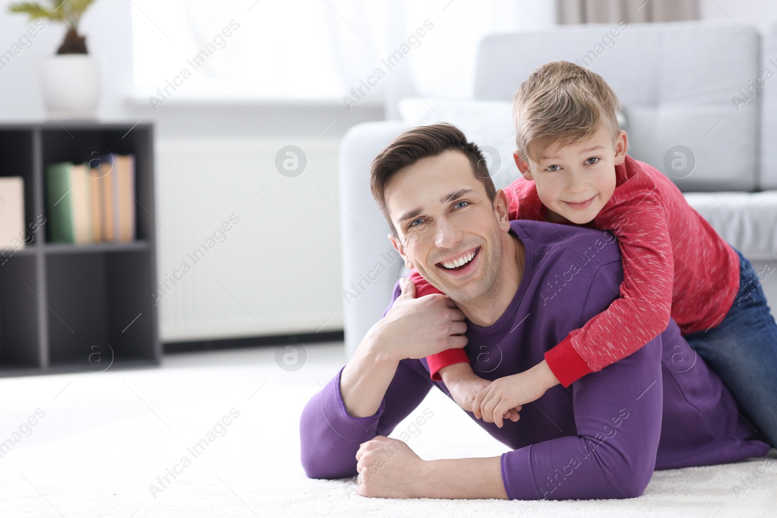 Photo of Son hugging his dad on floor at home