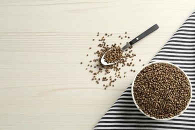 Photo of Ceramic bowl with chia seeds on white wooden table, flat lay and space for text. Cooking utensils