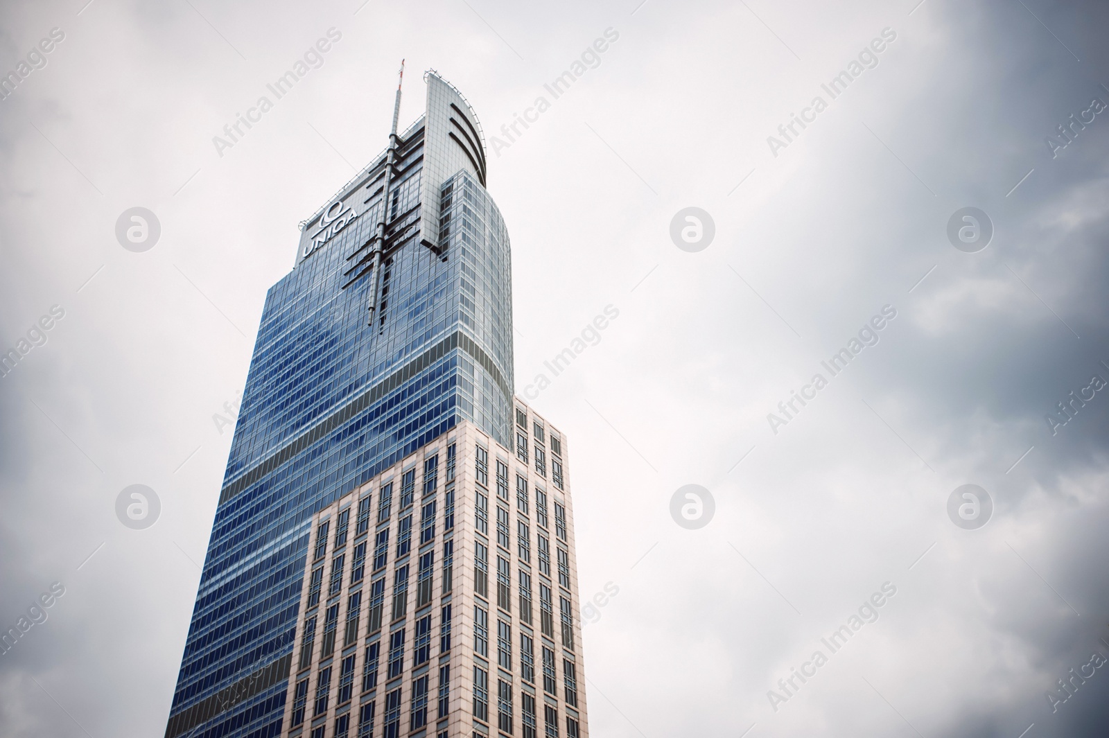 Photo of Warsaw, Poland - May 28, 2022: Beautiful Uniqa building under cloudy sky, low angle view