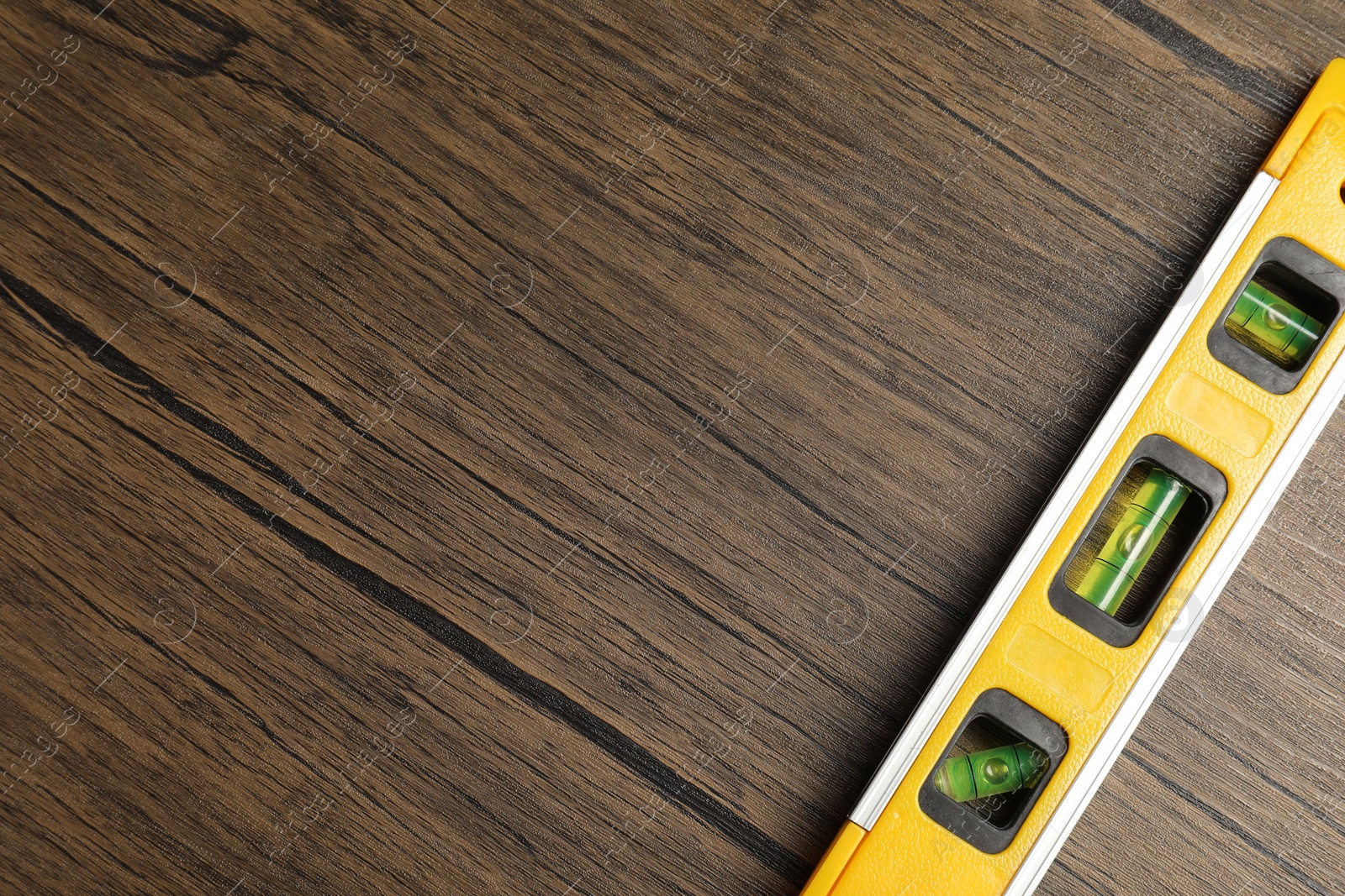 Photo of Building level on wooden table, top view. Space for text