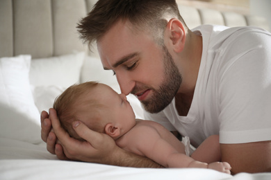 Photo of Father with his newborn son at home