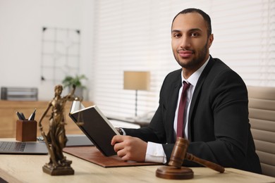 Photo of Successful lawyer with book at table in office