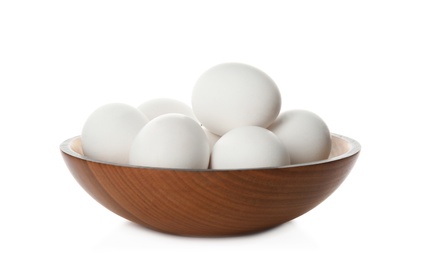 Bowl with raw chicken eggs on white background