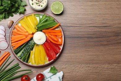 Photo of Fresh raw vegetable sticks and sauce on wooden table, flat lay. Space for text