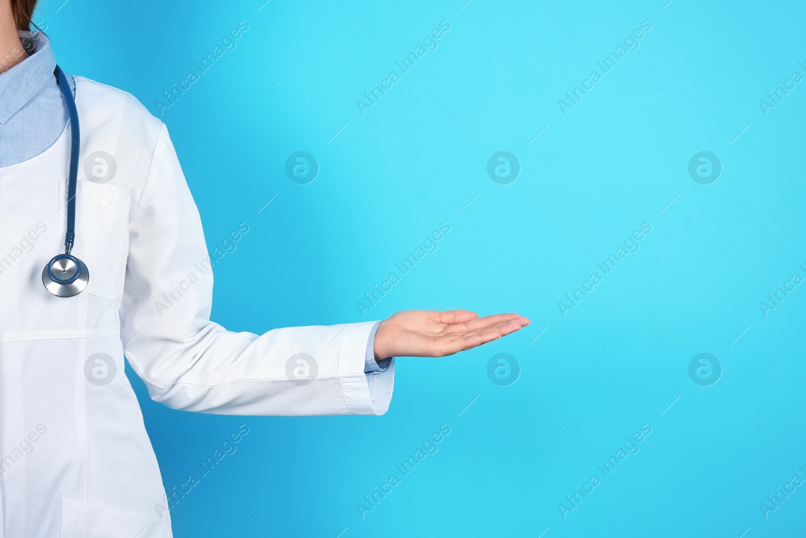 Photo of Female doctor offering helping hand on color background, closeup with space for text