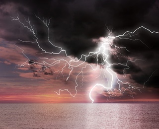 Image of Dark cloudy sky with lightning striking sea. Picturesque thunderstorm 