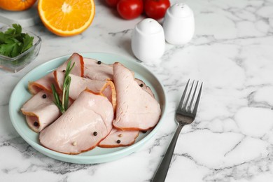 Photo of Delicious cut ham with rosemary and peppercorns served on white marble table