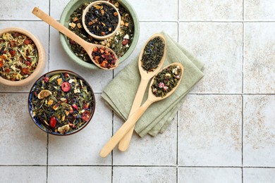 Photo of Many different herbal teas on white tiled surface, flat lay