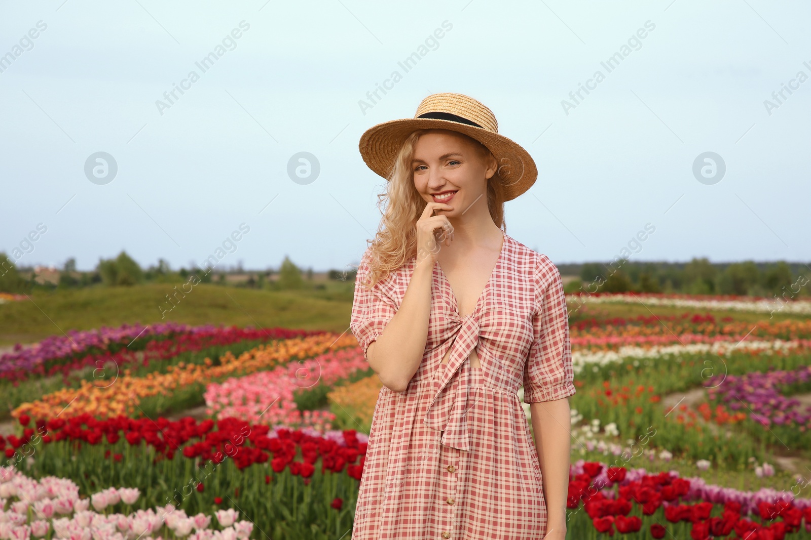 Photo of Happy woman in beautiful tulip field outdoors