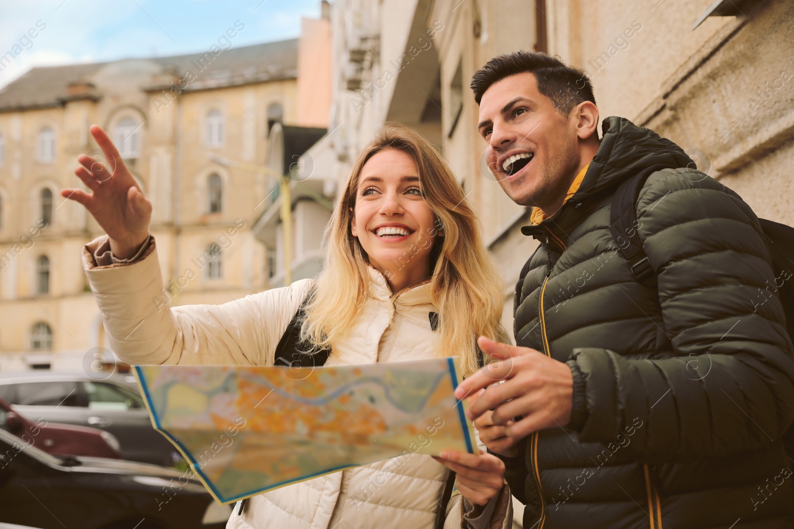 Photo of Couple of tourists with map on city street