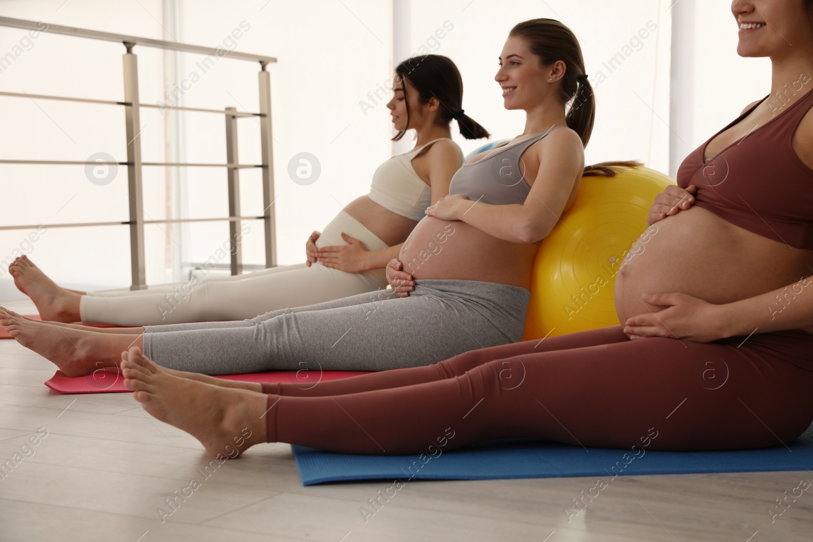 Photo of Group of pregnant women doing exercises in gym. Preparation for child birth