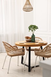 Dining room interior with comfortable furniture and green branches