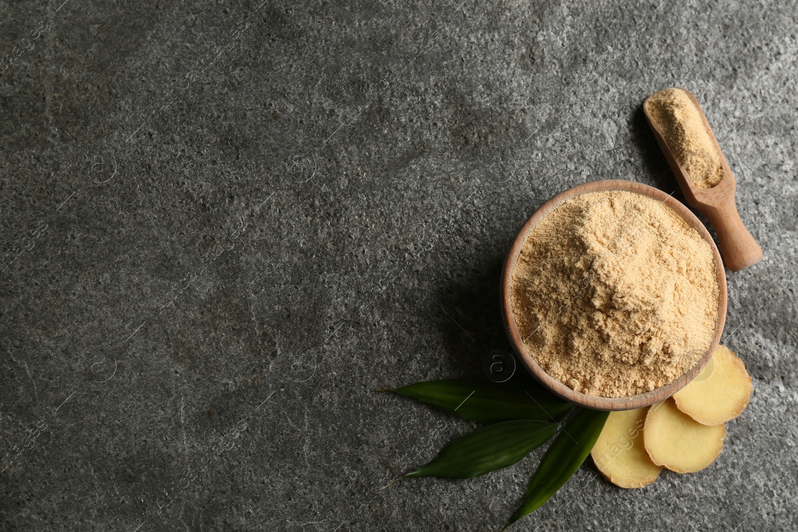 Photo of Dry ginger powder, fresh root and leaves on grey table, flat lay. Space for text