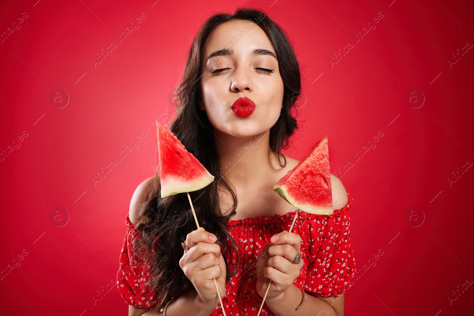 Photo of Beautiful young woman with watermelon on red background