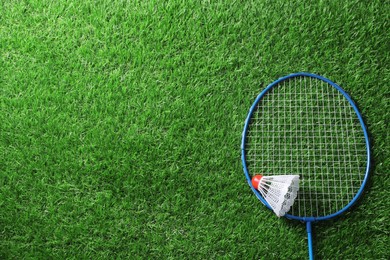 Photo of Two badminton racket and shuttlecock on green grass, top view with space for text