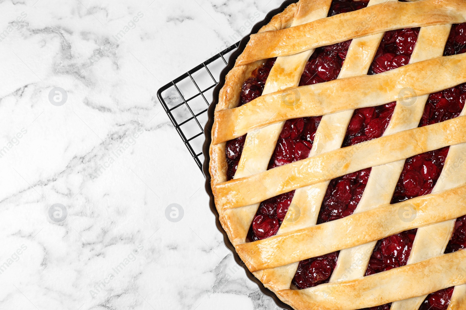 Photo of Delicious fresh cherry pie on white marble table, top view. Space for text