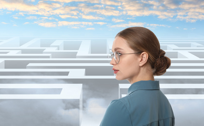 Image of Young businesswoman looking for way out of maze