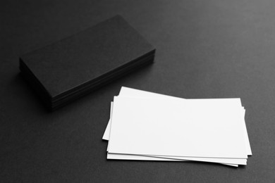 Photo of Blank business cards on black background, closeup. Mockup for design