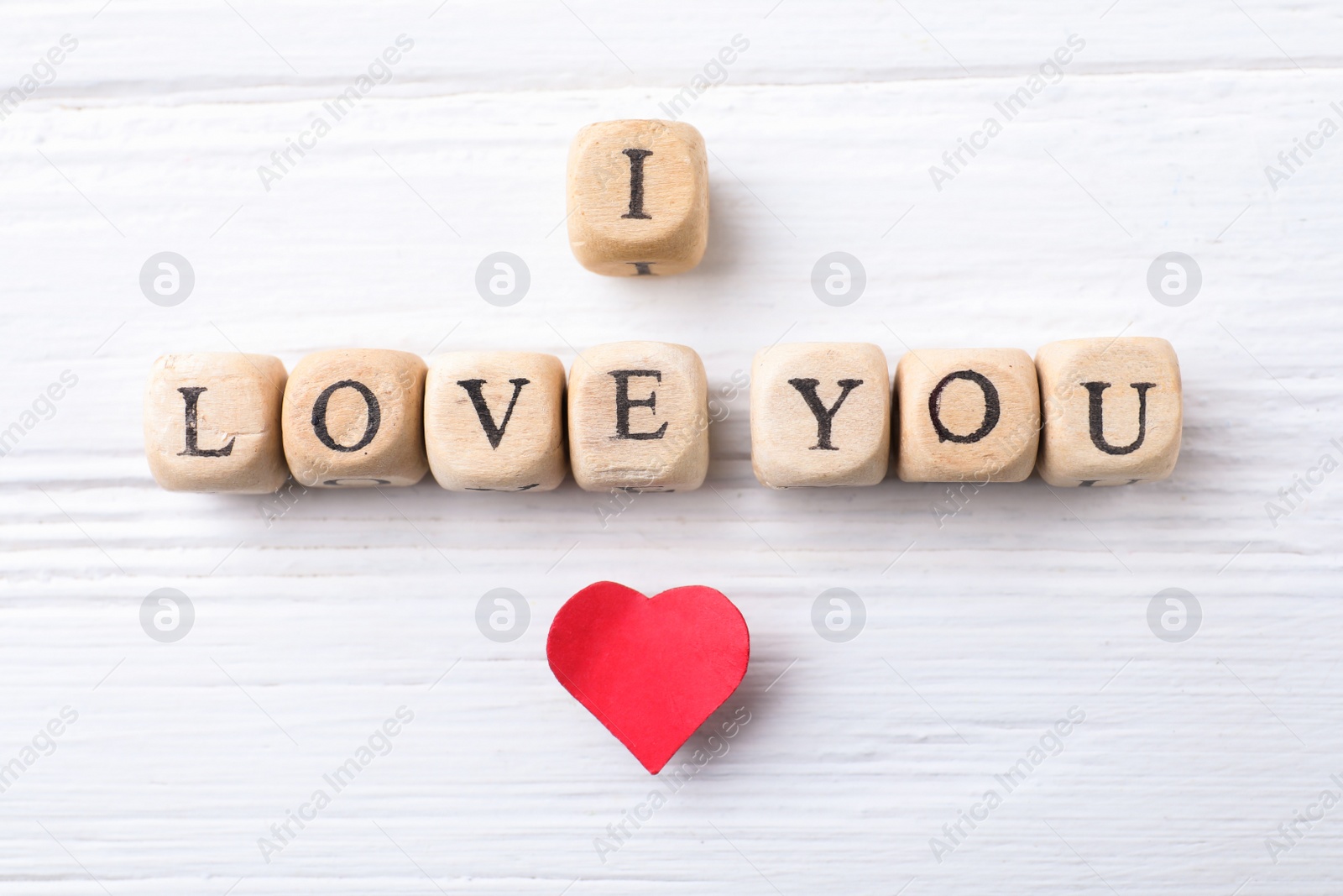 Photo of Cubes with words I Love You and paper heart on white wooden background, flat lay