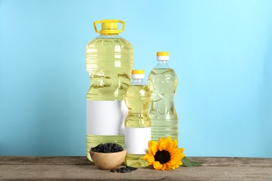 Photo of Bottles of cooking oil, sunflower and seeds on wooden table