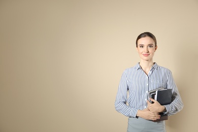 Portrait of young female teacher on beige background. Space for text