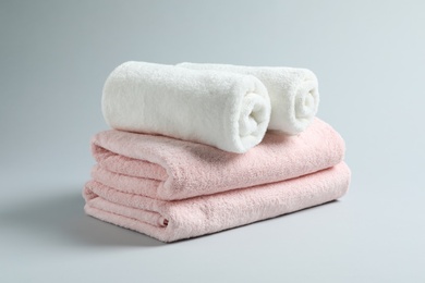 Photo of Stack of fresh towels on light background