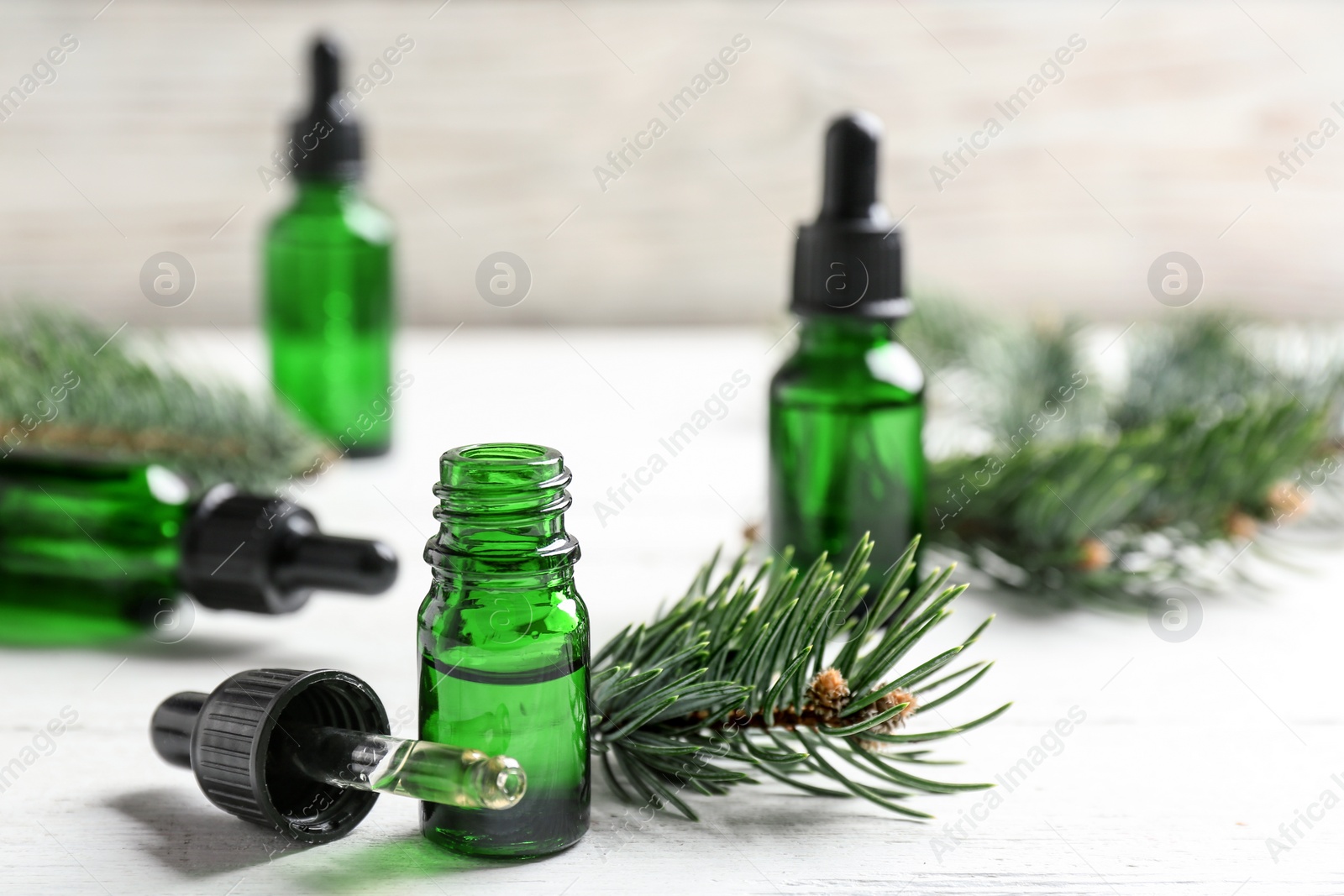 Photo of Composition with bottle of conifer essential oil on white wooden table. Space for text