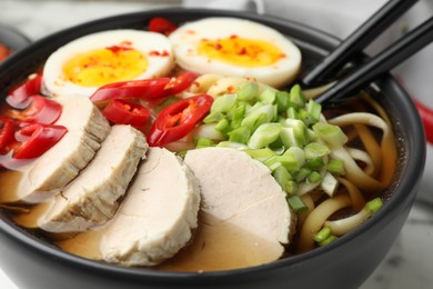 Delicious ramen in bowl on table, closeup. Noodle soup