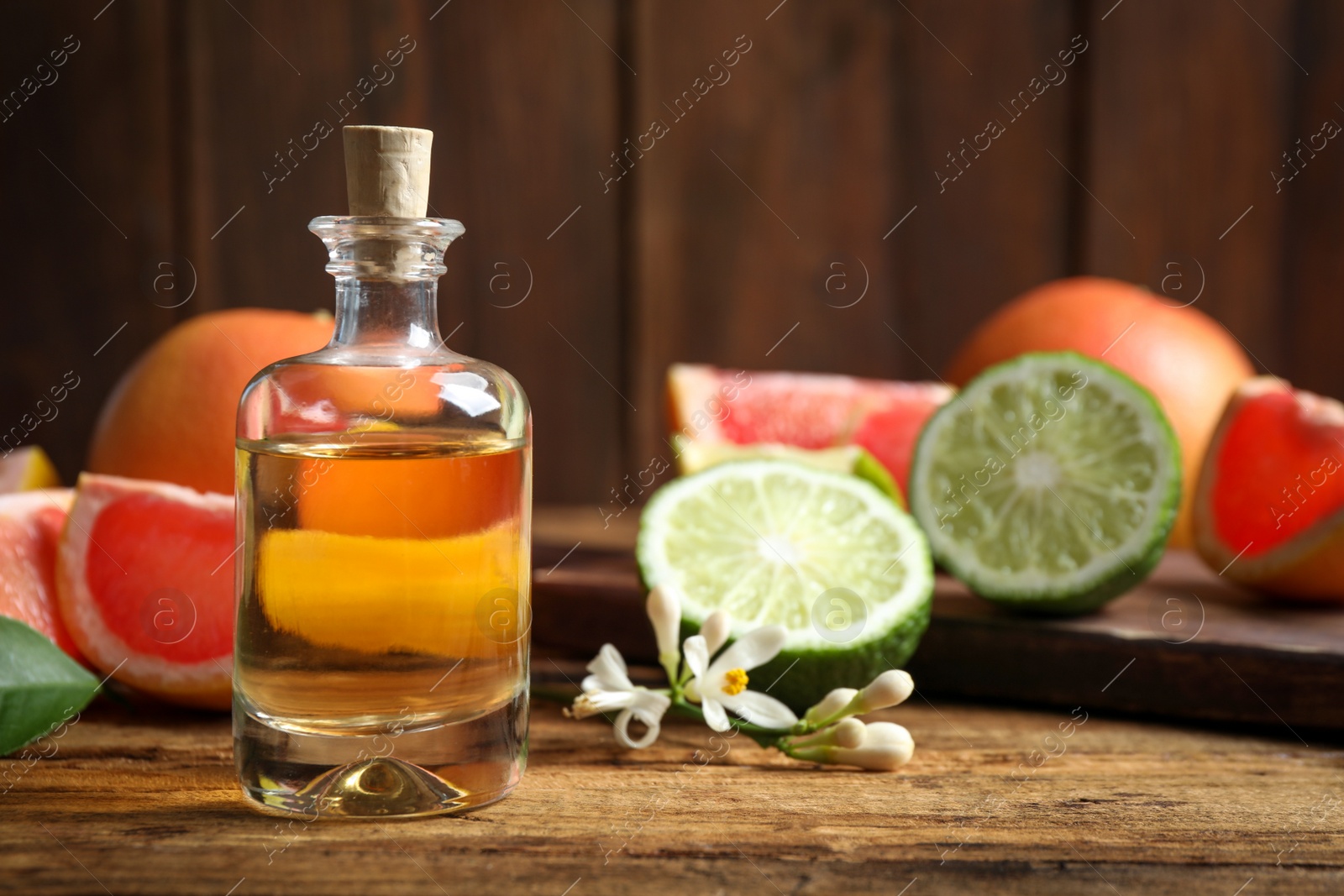 Photo of Citrus essential oil on wooden table. Space for text