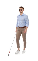 Young blind person with long cane walking on white background