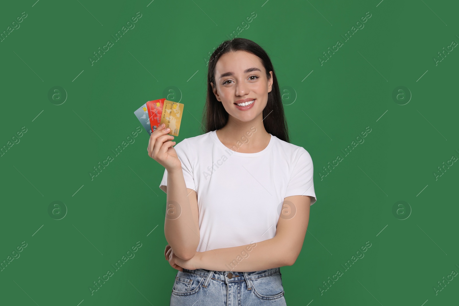 Photo of Happy woman with credit cards on green background. Debt free